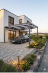 Carport aluminium sur mesure autoportant gris anthracite sur allée paysagée devant maison contemporaine avec voiture