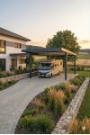 Carport aluminium sur mesure avec éclairage LED intégré de nuit devant maison moderne en pierre avec voiture garée