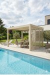 Pergola aluminium sur mesure autoportante beige avec claustra décoratif salon extérieur et piscine