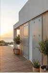 Persienne bois gris clair fermée sur maison moderne en bord de mer avec terrasse