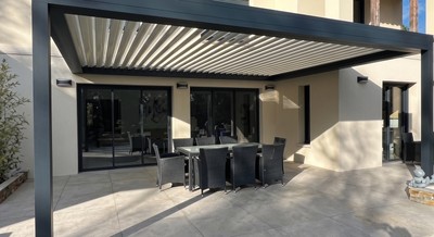 Pergola bioclimatique adossée à une maison moderne - baies vitrées et salon de terrasse