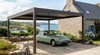 Carport aluminium autoporté devant une maison en pierre - vue mer