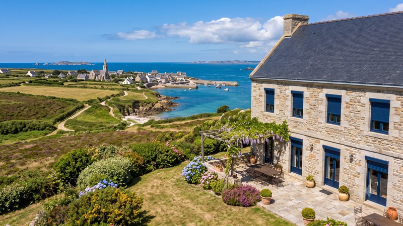 Volets roulants rénovation bleus sur maison en pierre du Finistère, vue sur le port