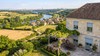 Volets roulants rénovation gris clair sur maison en pierre en Île-de-France, Paris à l'horizon