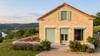 Volet roulant rénovation solaire sur mesure vert sauge sur maison en pierre en Dordogne, assorti aux volets battants