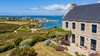 Volets roulants rénovation bleus sur maison en pierre du Finistère, vue sur le port
