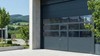 Porte sectionnelle avec portillon intégré et panneaux vitrés – accès piéton indépendant sur bâtiment