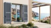 Volet battant PVC persienné gris-bleu sur une maison au bord de la Méditerranée, face à une crique