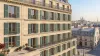 Volets battants bois persiennés verts sur une façade haussmannienne à Paris