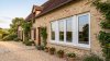 Fenêtre PVC 4 vantaux tout ouvrant sur mesure – vue extérieure, maison en pierre