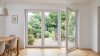 Porte-fenêtre PVC 3 vantaux tout ouvrant sur mesure – vue intérieure, vantail de droite ouvert sur la terrasse