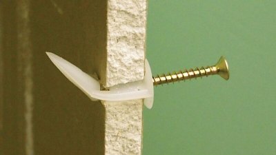Cheville Tacoplac dans une plaque de plâtre vue en coupe, vis de 4 mm engagée (vis non fournie)